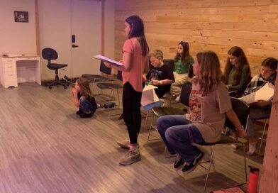6-8 young students in Kismet studio holding scripts.