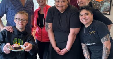 8 staff gathered around in a cafe