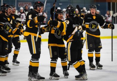 Nanaimo Buccaneers team on the ice in black and gold hockey uniforms