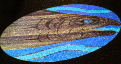 Image of a fish in water illuminated in a circle against black background