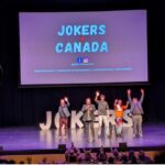 Comedians on a black stage with purple lighting