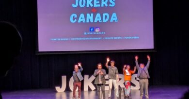 Comedians on a black stage with purple lighting