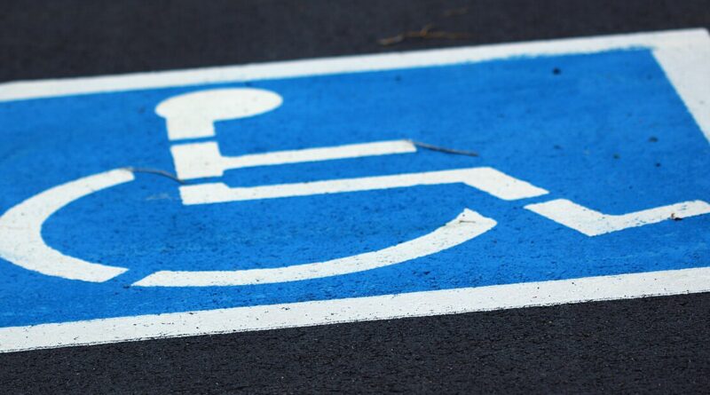 wheelchair parking symbol in blue on black background