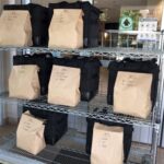 Brown paper bags of food on a shelf for pickup