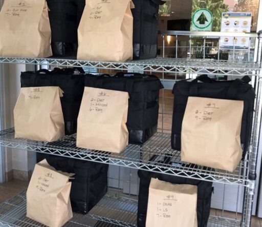 Brown paper bags of food on a shelf for pickup