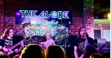 shot of the crowd and stage with musicians in background, neon colours