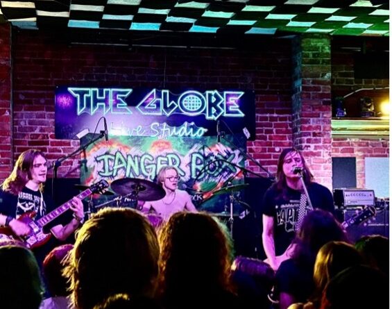 shot of the crowd and stage with musicians in background, neon colours