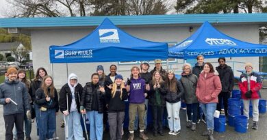 VIU Surfrider Club volunteers at a Clean-up event under a blue tent.