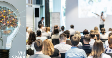 Audience in a white room looking at a stage